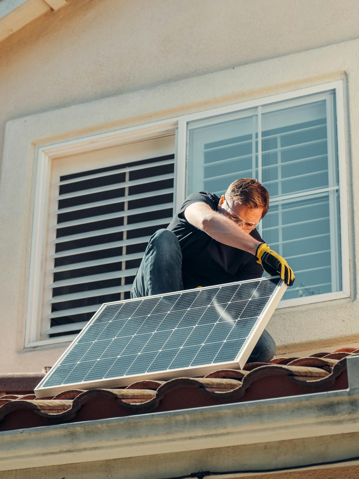 Installateur monteert zonnepanelen op woningdak — duurzame renovatie in uitvoering